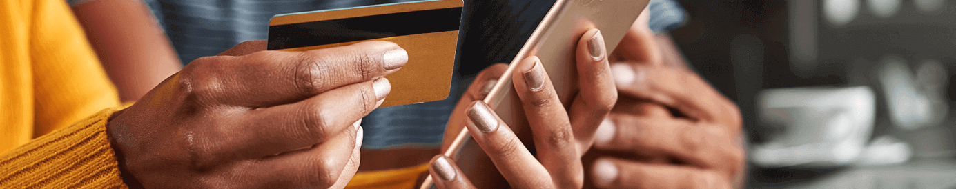 Hands holding a credit card and a smartphone