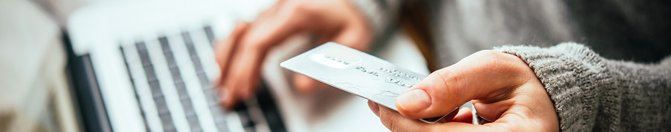 A picture of someone on a laptop entering their credit card information.