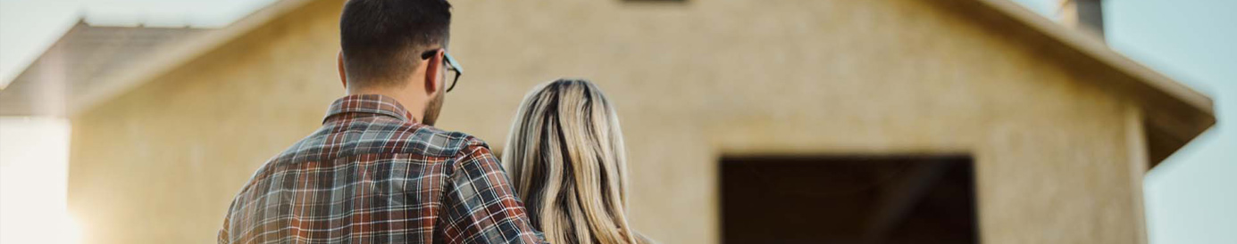 Una pareja de espaldas a la c&aacute;mara mirando la reconstrucci&oacute;n de su casa.