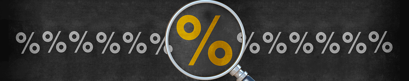 There is a row of grey percentage rate symbols on a chalkboard background. In the center, a magnifying glass is making one yellow percentage rate symbol look larger than the rest.