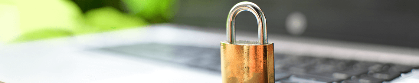 A golden lock sits on top of a laptop.