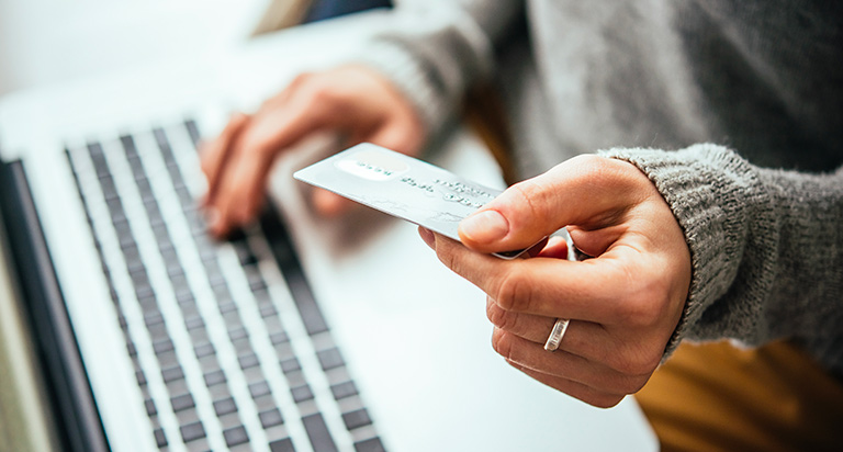 A picture of someone on a laptop entering their credit card information.