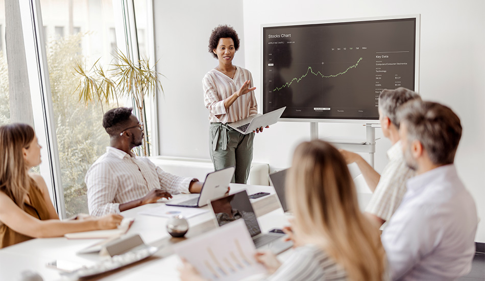 In a corporate boardroom at EFX, a woman leads a presentation on the future of AI in the financial industry.